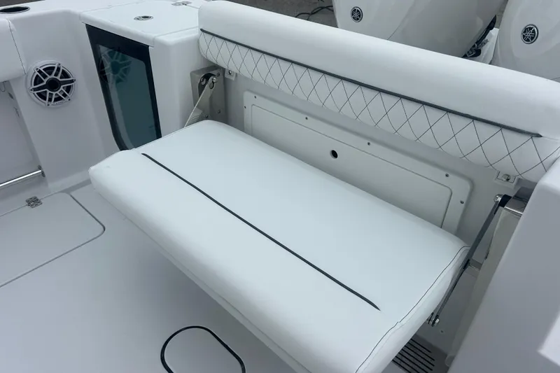 Slide: The Image of 2026 Sportsman Open 252 Center Console boat interior with white cushioned seating. - 16