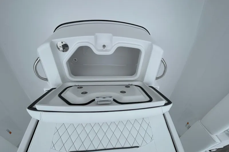 Slide: The Image of 2026 Sportsman Open 252 Center Console boat storage compartment, open view, white interior. - 24