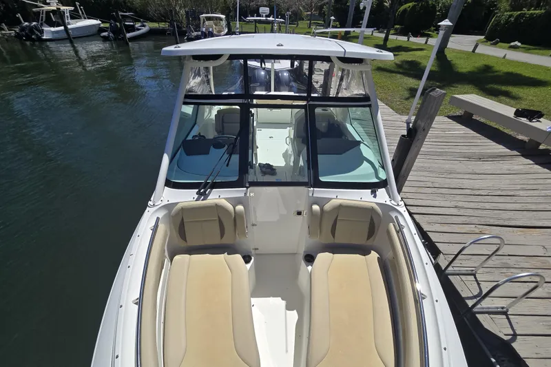 Slide: The Image of 2020 Pursuit DC 266 Dual Console with twin Yamaha 200 engines docked by a pier. - 20
