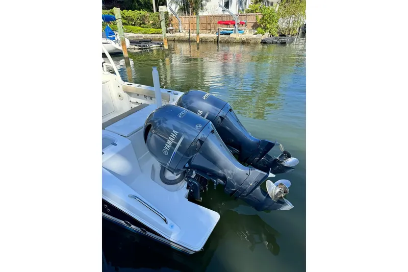 Slide: The Image of 2020 Pursuit DC 266 Dual Console with twin Yamaha outboard motors on a calm waterway. - 22