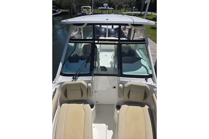 Slide: The Image of 2020 Pursuit DC 266 Dual Console storage compartment with organized tackle boxes and equipment. - 23