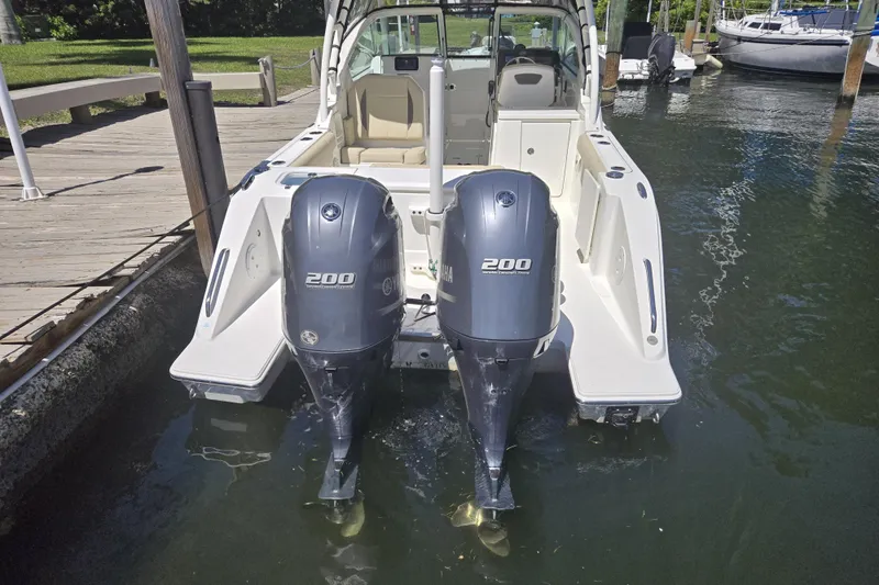 Slide: The Image of 2020 Pursuit DC 266 Dual Console boat docked on calm water. - 3