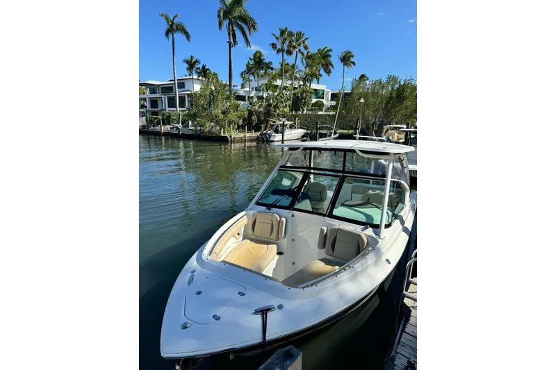 Slide: The Image of 2020 Pursuit DC 266 Dual Console boat on stands, showing underside and motor. - 36