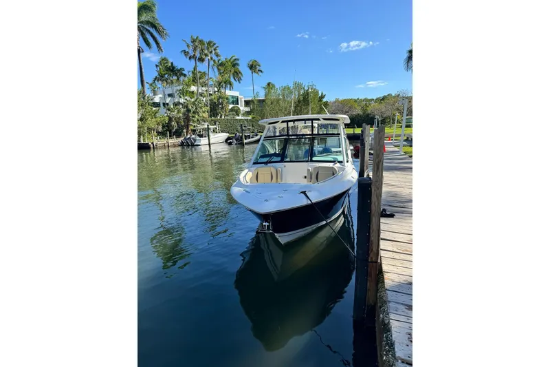 Slide: The Image of 2020 Pursuit DC 266 Dual Console boat on stands under a clear blue sky. - 37