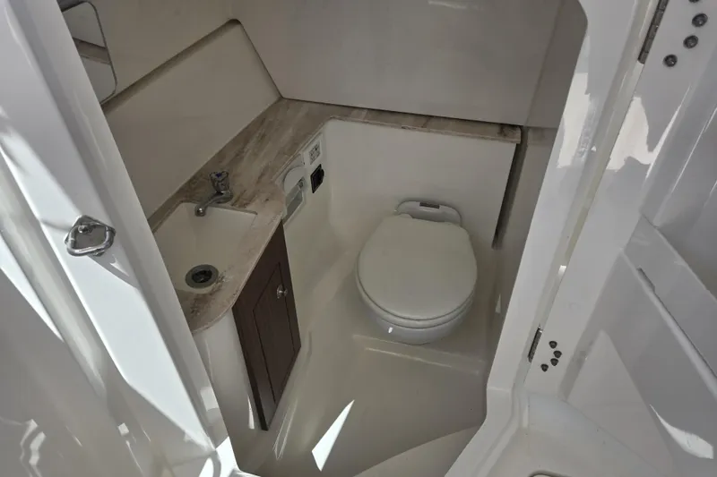 Slide: The Image of 2020 Pursuit DC 266 Dual Console boat on stands, reflecting sunlight. - 39