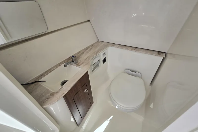 Slide: The Image of 2020 Pursuit DC 266 Dual Console boat docked in a serene marina setting. - 4