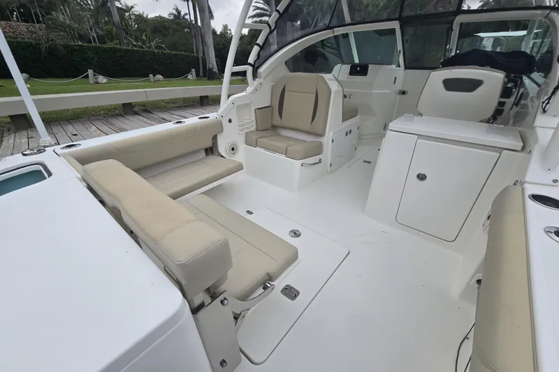 Slide: The Image of 2020 Pursuit DC 266 Dual Console boat on stands, with palm trees in the background. - 42