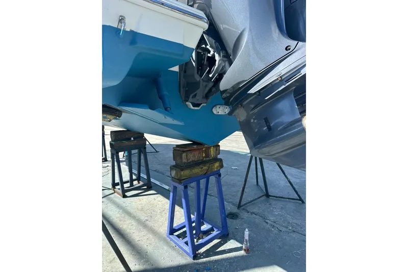 Slide: The Image of 2020 Pursuit DC 266 Dual Console boat docked by palm trees and calm water. - 46