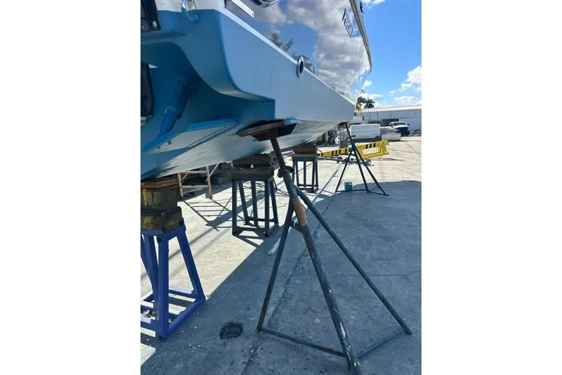 Slide: The Image of 2020 Pursuit DC 266 Dual Console boat with spacious deck and twin engines docked by the water. - 48