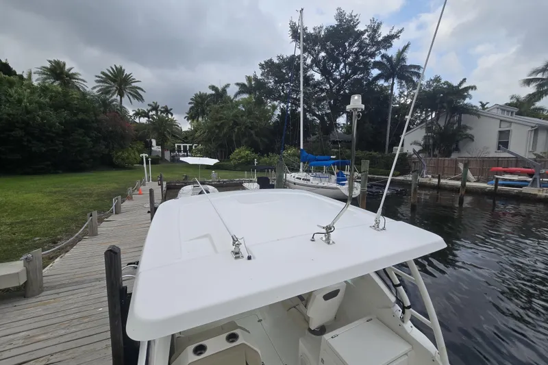 Slide: The Image of 2020 Pursuit DC 266 Dual Console boat with spacious seating, docked by calm waters. - 5