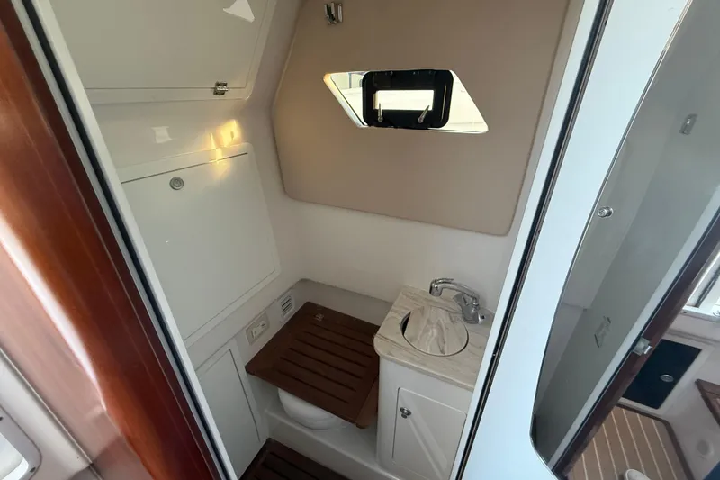 Slide: The Image of 2018 Edgewater 370CC boat interior with white seating and speaker detail. - 17