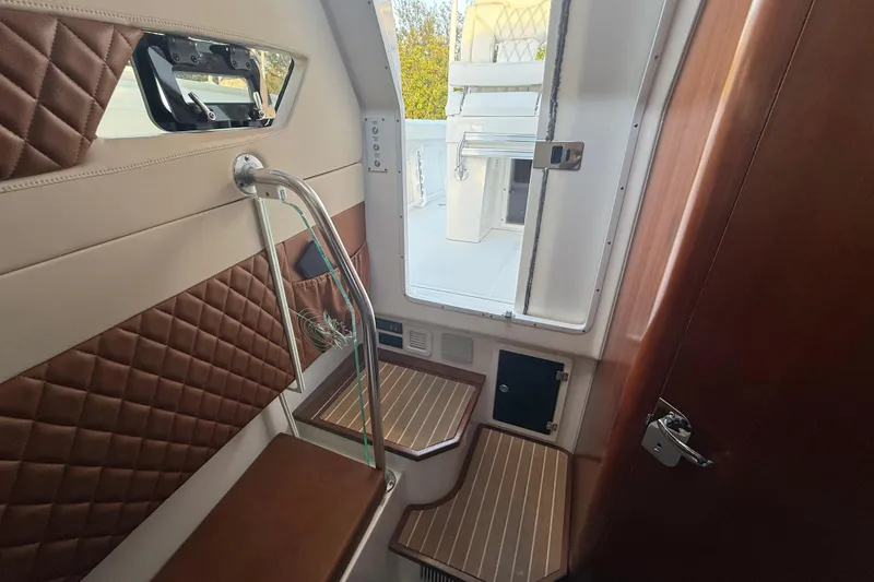 Slide: The Image of 2018 Edgewater 370CC boat bathroom with sink, toilet, and window. - 19