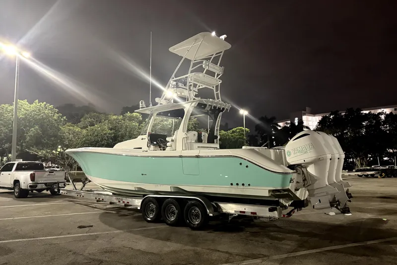 Slide: The Image of 2018 Edgewater 370CC boat with triple 300 horsepower outboard engines in a parking lot at night. - 4