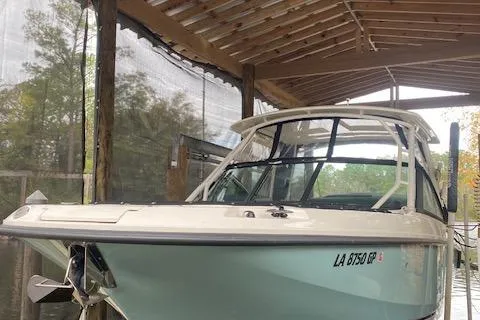 Slide: The Image of 2017 Boston Whaler 270 Vantage boat docked under a wooden canopy. - 3