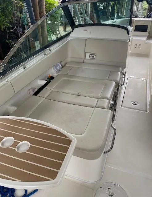 Slide: The Image of 2017 Boston Whaler 270 Vantage interior with cushioned seating and table. - 5