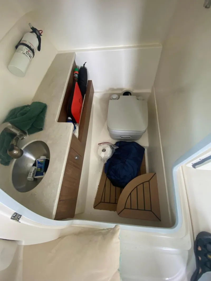 Slide: The Image of 2017 Boston Whaler 270 Vantage interior with sink, storage, and portable toilet. - 8