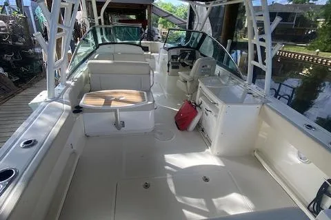 Slide: The Image of 2017 Boston Whaler 270 Vantage boat interior with seating and helm, docked by the water. - 9