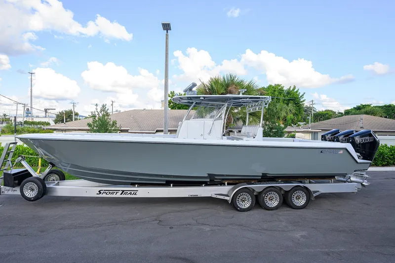 The Image of 2022 Contender 39 ST boat on trailer, parked outdoors under a clear sky. - 0