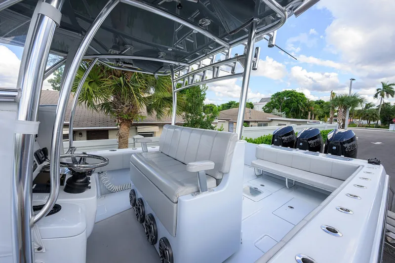 Slide: The Image of 2022 Contender 39 ST boat interior with seating, steering, and triple engines. - 12