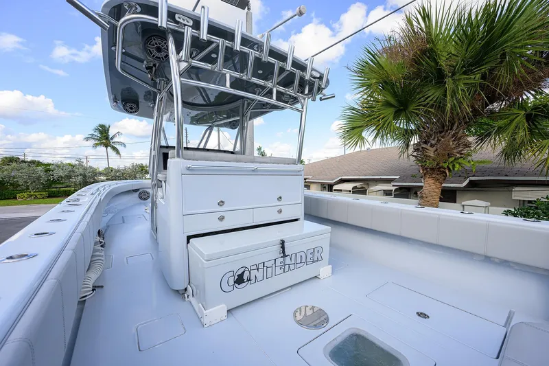 Slide: The Image of 2022 Contender 39 ST boat deck with storage, palm tree, and clear sky background. - 18
