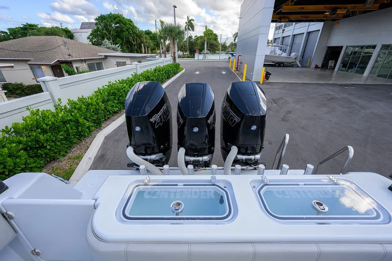 Slide: The Image of 2022 Contender 39 ST boat with triple outboard engines at a marina. - 25