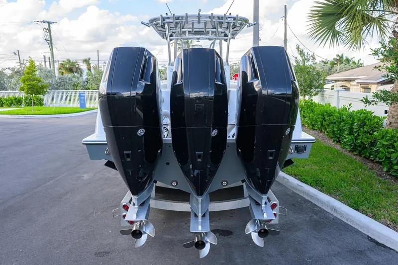 Slide: The Image of 2022 Contender 39 ST boat with triple outboard engines, parked on a sunny day. - 26
