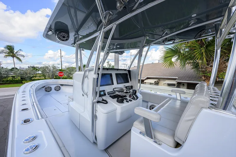 Slide: The Image of 2022 Contender 39 ST boat interior with modern helm and seating, under a clear blue sky. - 3