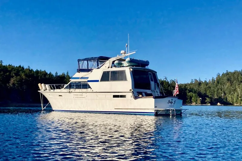Slide: The Image of 1987 Californian 55 Cockpit Motor Yacht on serene water with forested background. - 1