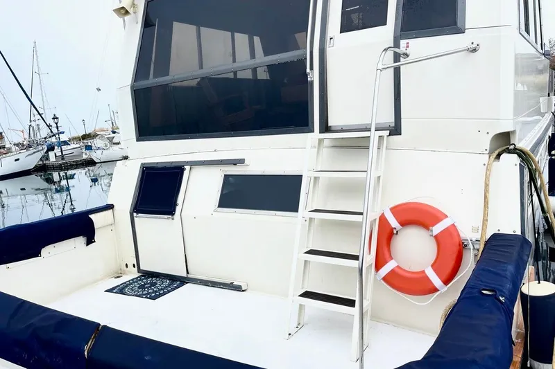 Slide: The Image of 1987 Californian 55 Cockpit Motor Yacht with ladder and lifebuoy in marina. - 14