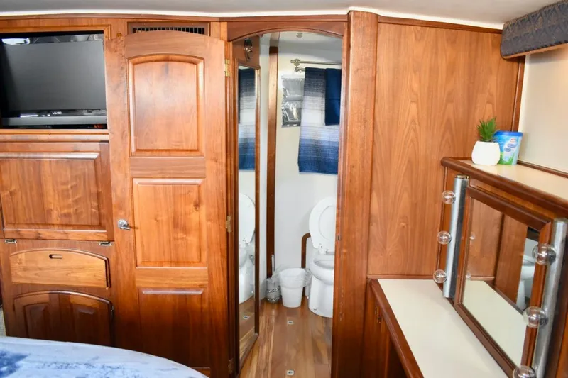 Slide: The Image of 1987 Californian 55 Cockpit Motor Yacht interior with wood cabinetry and bathroom view. - 22