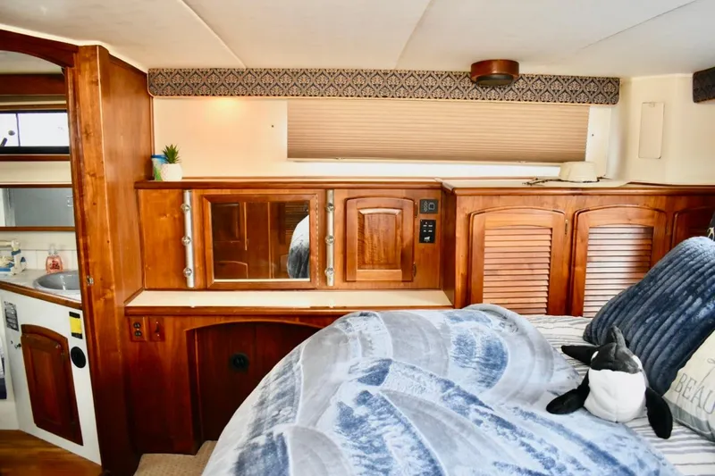 Slide: The Image of 1987 Californian 55 Cockpit Motor Yacht interior with wooden cabinetry and cozy bedding. - 23
