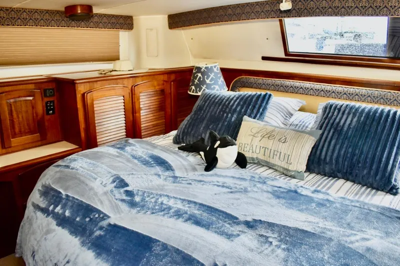 Slide: The Image of Luxurious bedroom interior of 1987 Californian 55 Cockpit Motor Yacht with plush blue bedding. - 25