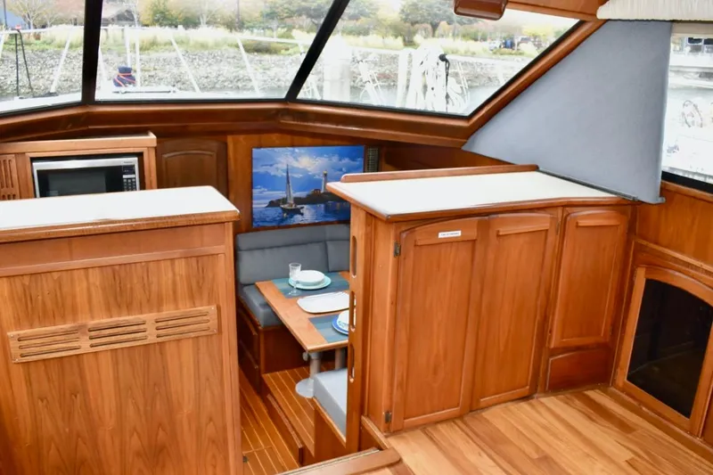 Slide: The Image of 1987 Californian 55 Cockpit Motor Yacht interior with wood finish and dining area. - 31