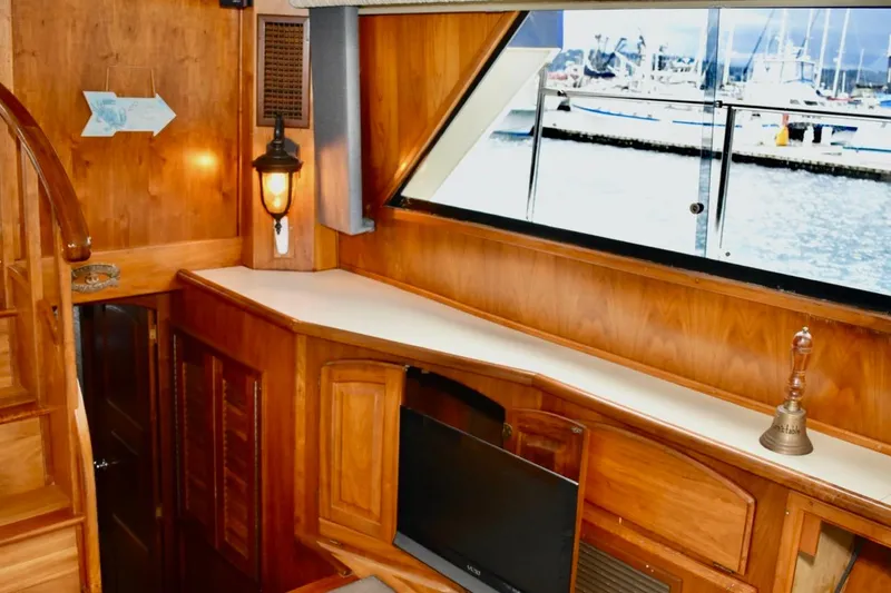 Slide: The Image of Interior of 1987 Californian 55 Cockpit Motor Yacht with wood paneling and large window view. - 32