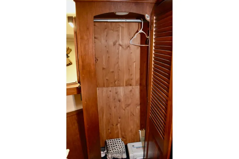 Slide: The Image of 1987 Californian 55 Cockpit Motor Yacht wooden closet interior with hangers and storage. - 44