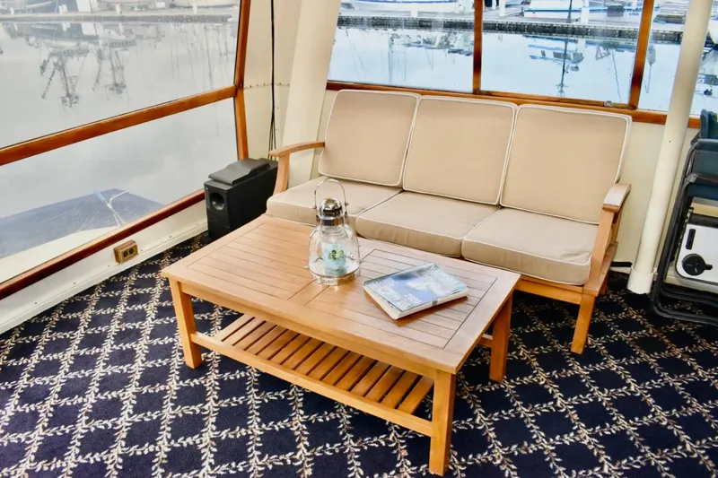 Slide: The Image of 1987 Californian 55 Cockpit Motor Yacht interior with wooden table, beige sofa, and nautical decor. - 6