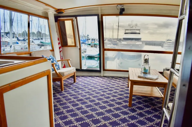 Slide: The Image of Interior of 1987 Californian 55 Cockpit Motor Yacht with marina view and cozy seating area. - 8