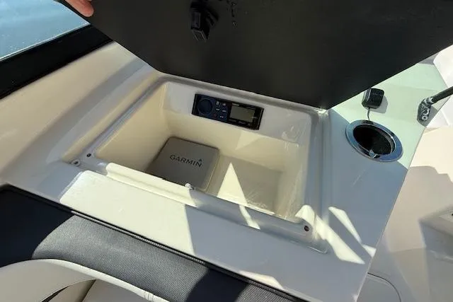 Slide: The Image of 2017 Sea Ray SPX 190 Outboard storage compartment with Garmin device and cup holder. - 24