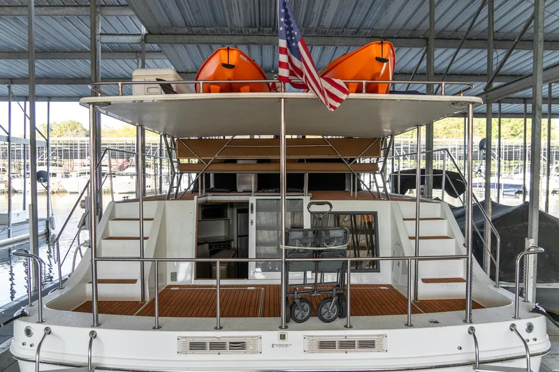 Slide: The Image of 1997 Harbor Master Stolkraft boat docked, featuring upper deck with kayaks and American flag. - 11