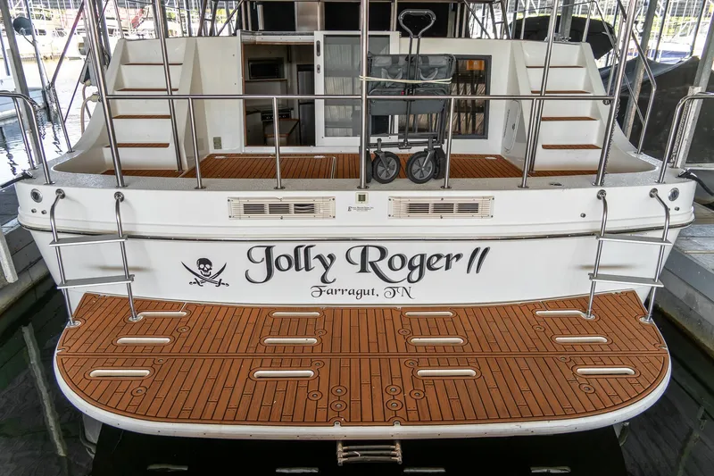 Slide: The Image of 1997 Harbor Master Stolkraft boat "Jolly Roger II" docked, featuring wooden deck and pirate theme. - 12