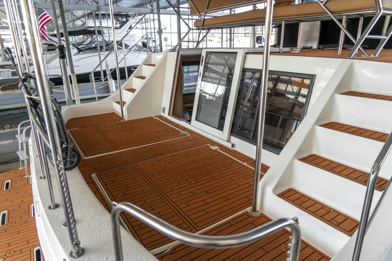 Slide: The Image of 1997 Harbor Master Stolkraft yacht deck with wooden flooring and stairs in a marina. - 14