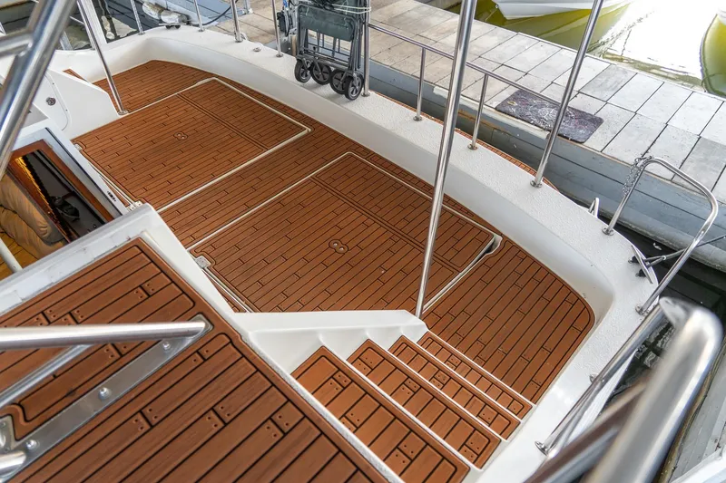 Slide: The Image of 1997 Harbor Master Stolkraft boat deck with teak flooring and stainless steel railings. - 17