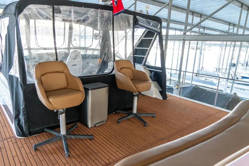 Slide: The Image of 1997 Harbor Master Stolkraft boat interior with brown swivel chairs and clear enclosure. - 18