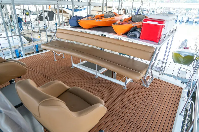 Slide: The Image of 1997 Harbor Master Stolkraft boat deck with seating, kayaks, and coolers in a marina setting. - 20