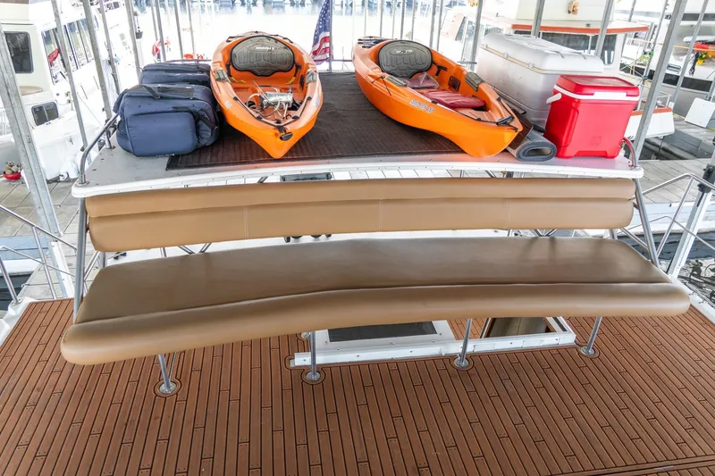 Slide: The Image of 1997 Harbor Master Stolkraft boat deck with kayaks, cooler, and seating. - 21