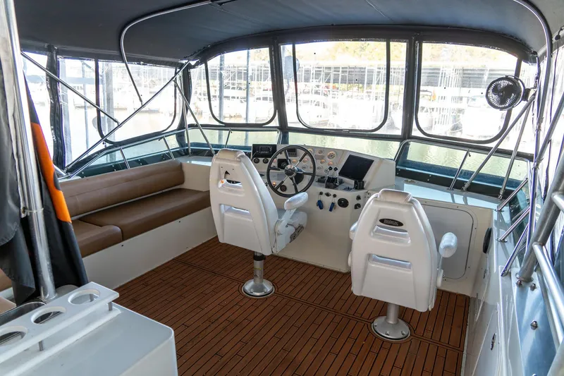 Slide: The Image of 1997 Harbor Master Stolkraft boat interior with helm, seating, and wooden flooring. - 22