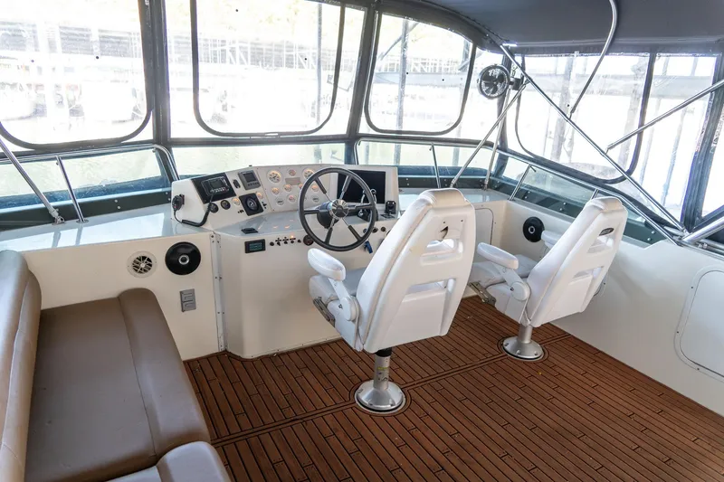 Slide: The Image of 1997 Harbor Master Stolkraft boat helm with dual seats and wooden flooring. - 24