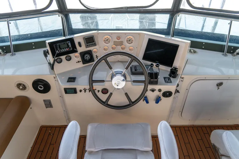 Slide: The Image of 1997 Harbor Master Stolkraft helm with steering wheel, gauges, and navigation equipment. - 26