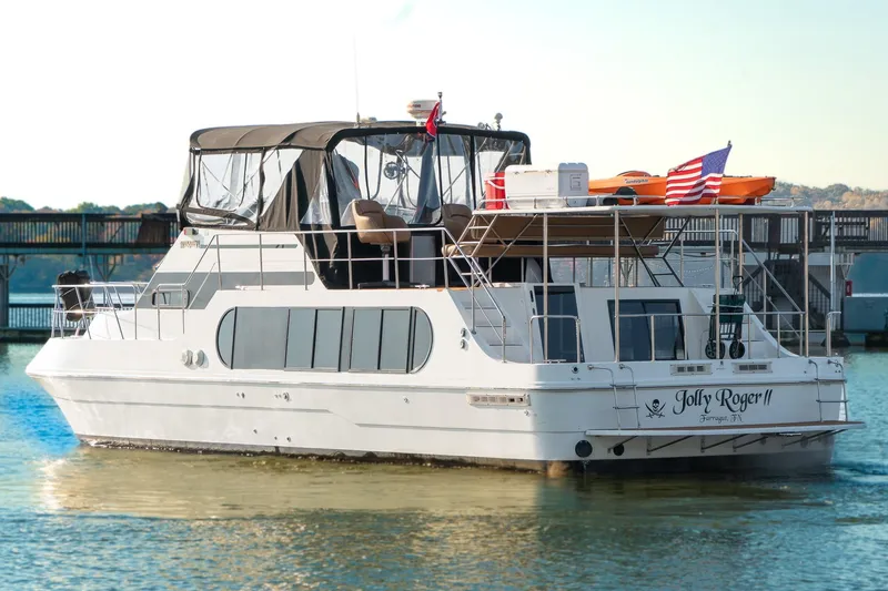 Slide: The Image of 1997 Harbor Master Stolkraft boat named "Jolly Roger II" on calm water with American flag. - 3