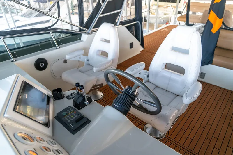 Slide: The Image of 1997 Harbor Master Stolkraft helm with modern controls and white captain chairs on teak flooring. - 30